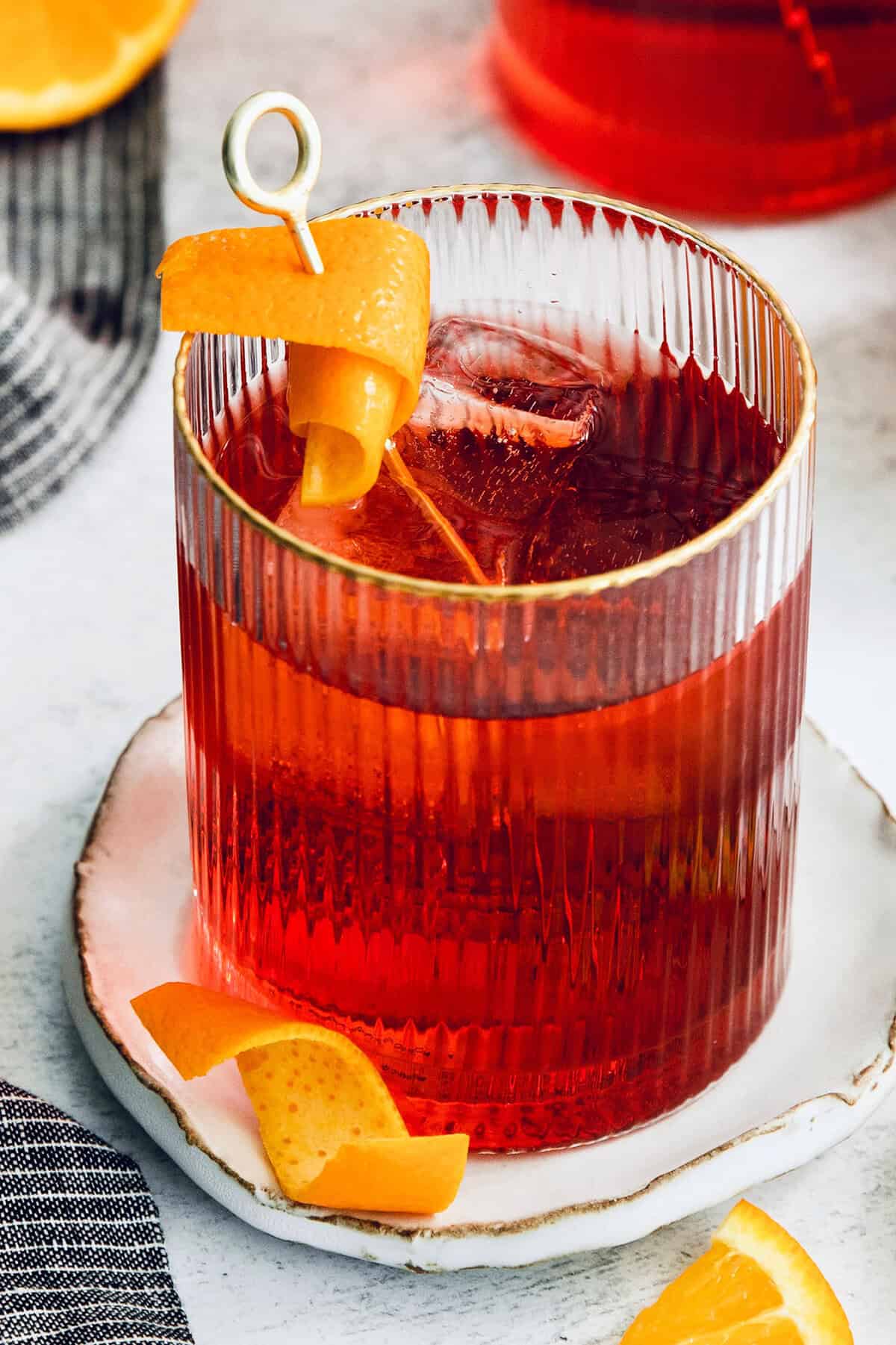 This classic Italian Negroni recipe features an easy 1-1-1 ratio of gin, Campari, and sweet vermouth and is served over ice. A twist of orange garnishes a Negroni.