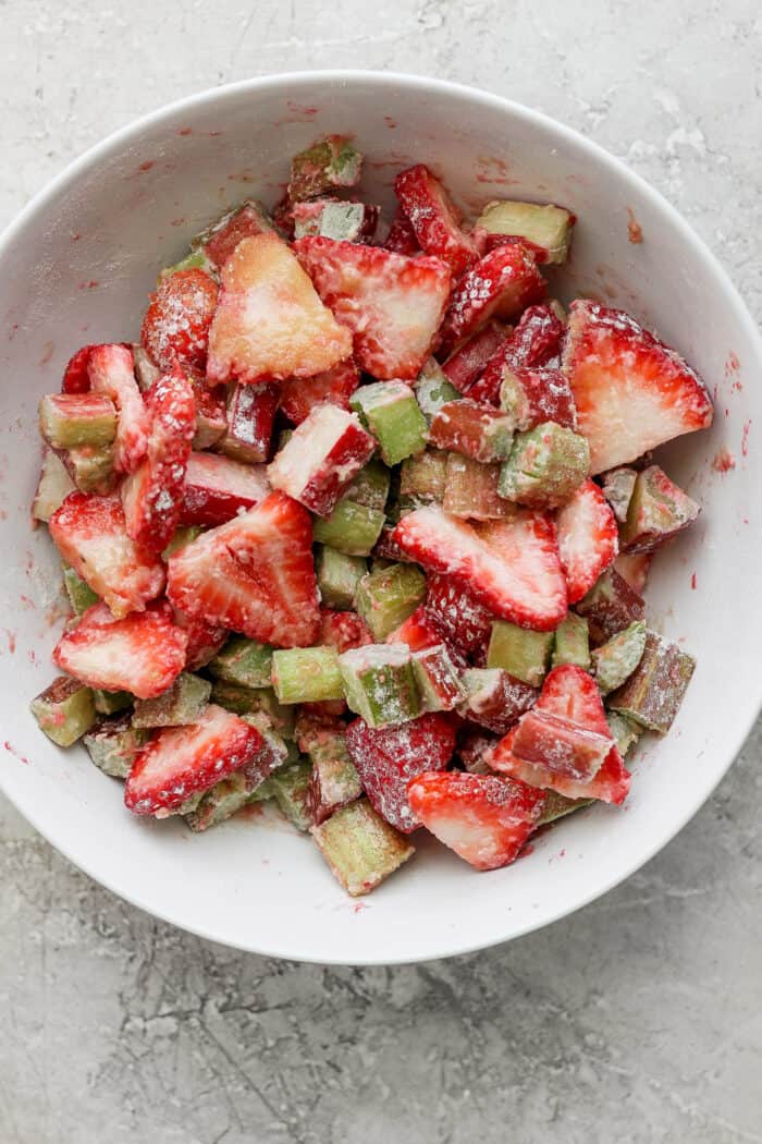 a white bowl with cut strawberries and rhubarb