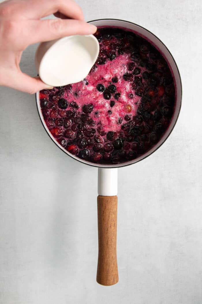 Sugar is added to the blueberries.