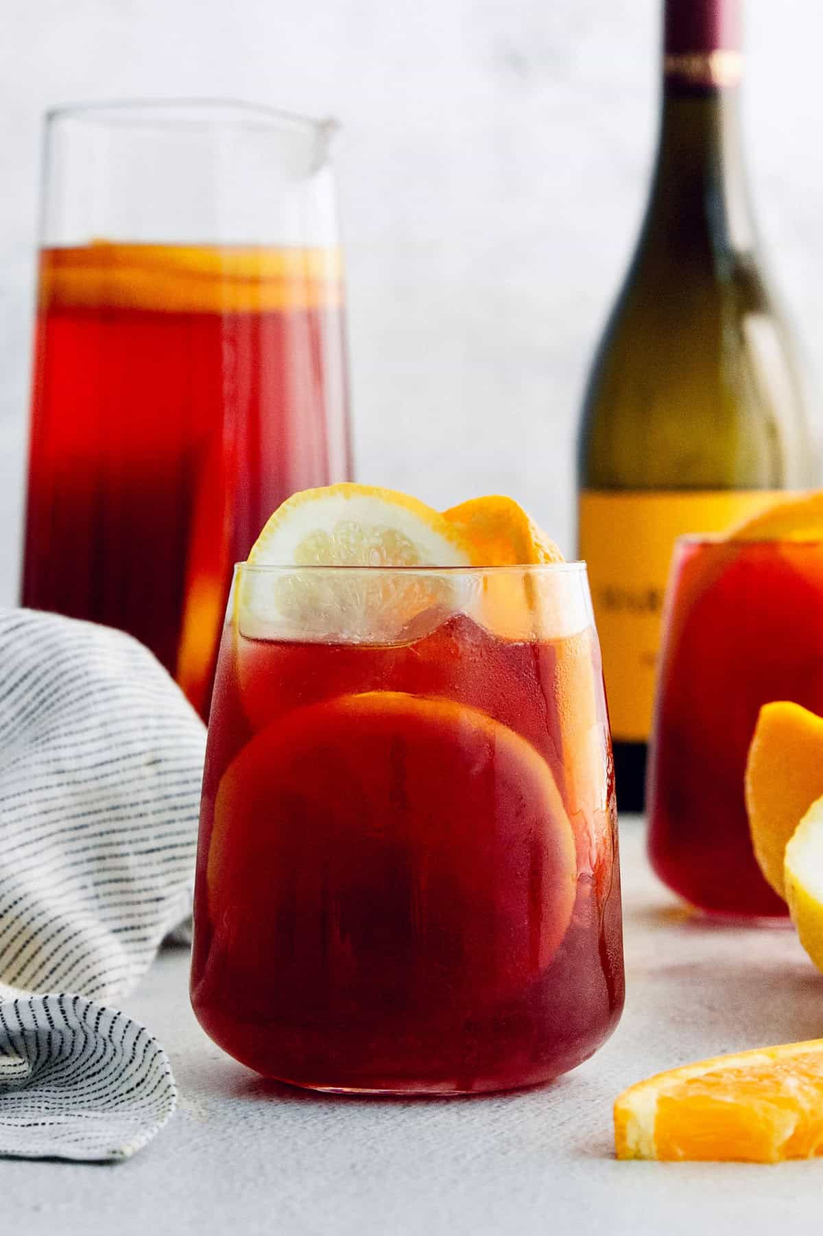 A glass of tinto de verano with a bottle of wine behind it.
