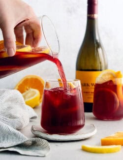 A hand pours tinto de verano from a pitcher in a glass.