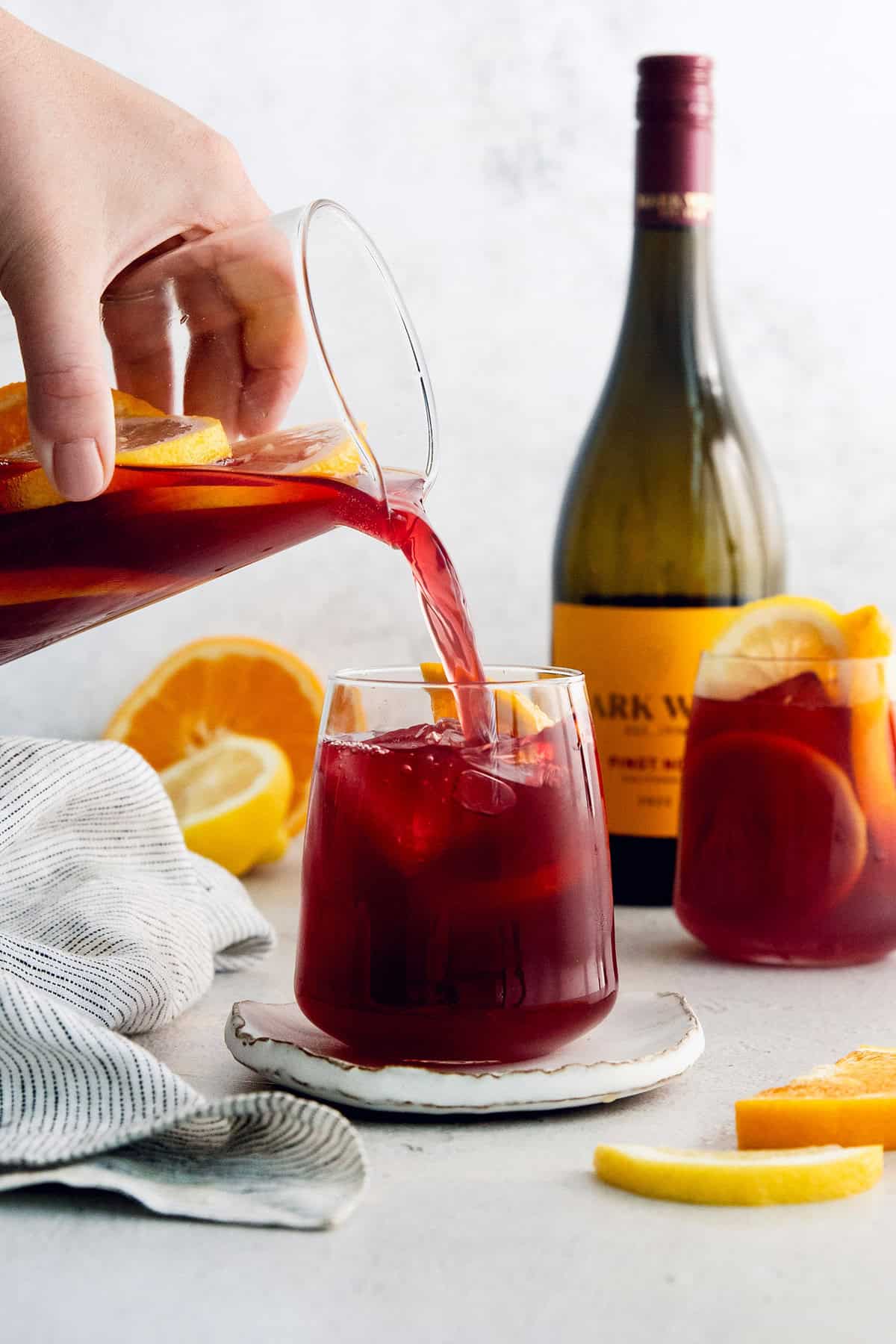 A hand pours tinto de verano from a pitcher in a glass.