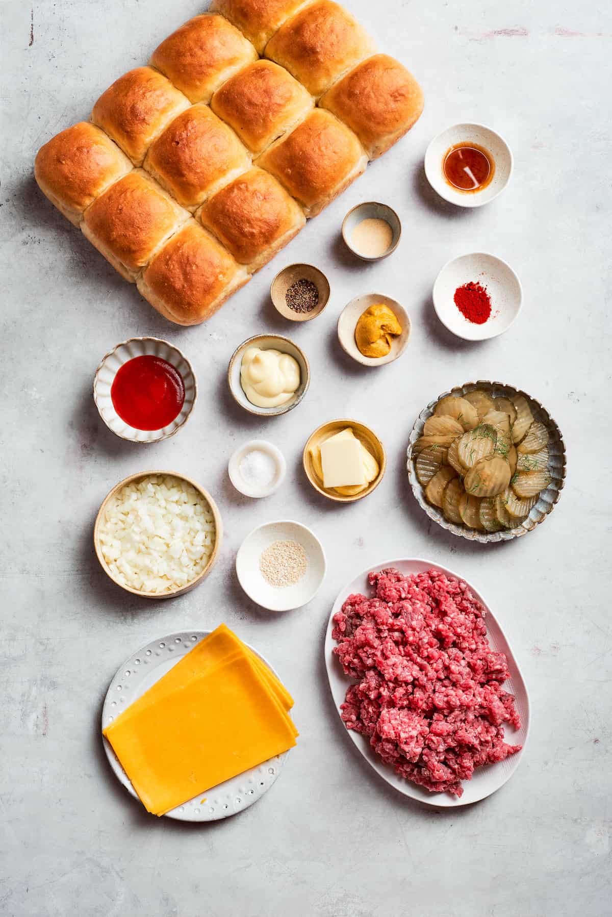 Ingredients for cheeseburger sliders include ground beef, roll, cheese, ketchup, mustard, mayonnaise, Worcestershire sauce, salt and pepper, pickles.