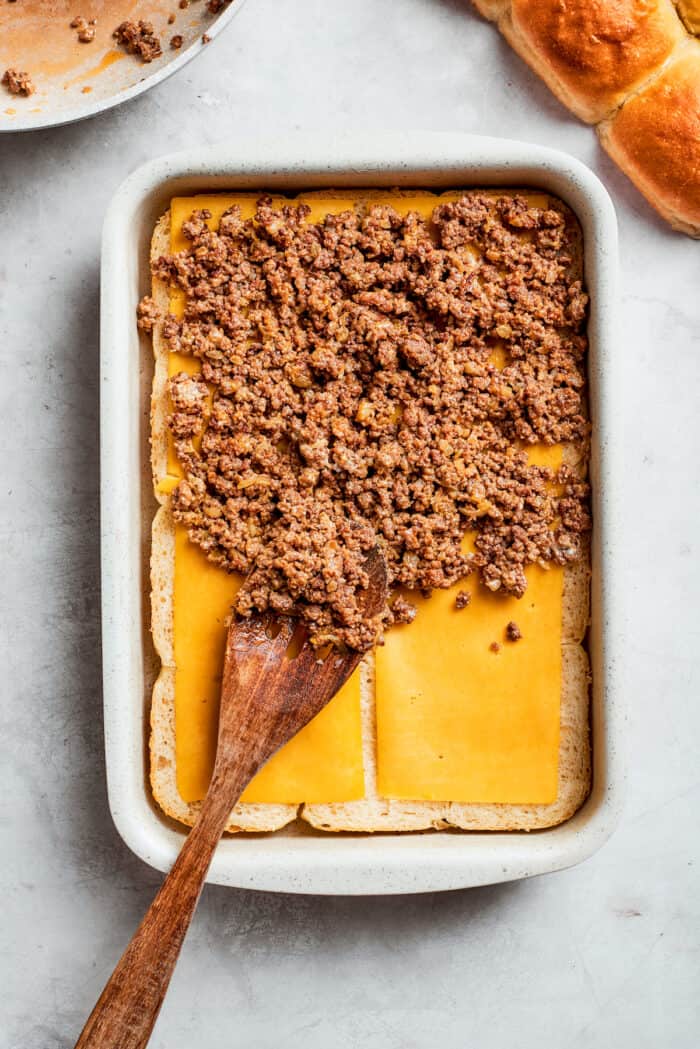 Ground beef is added to rolls and cheese.
