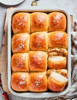 A pan of 12 baked cheeseburger sliders in a pan.