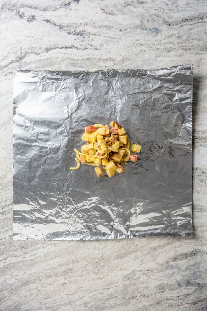 Potato pieces are placed in the middle of a piece of foil.