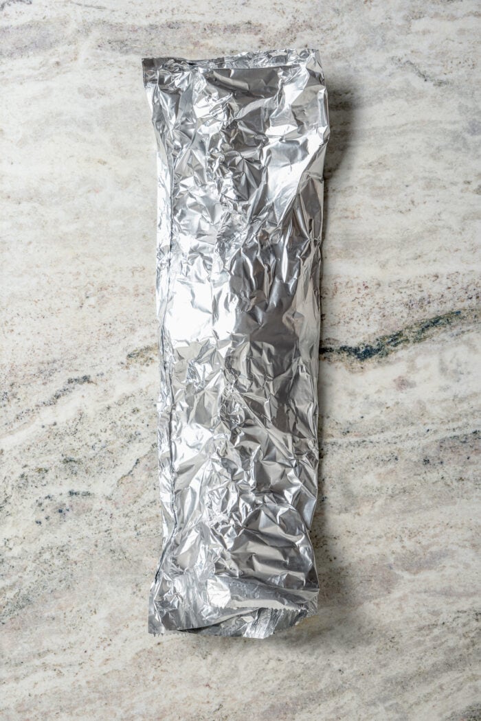 Potatoes are wrapped up a foil packet.