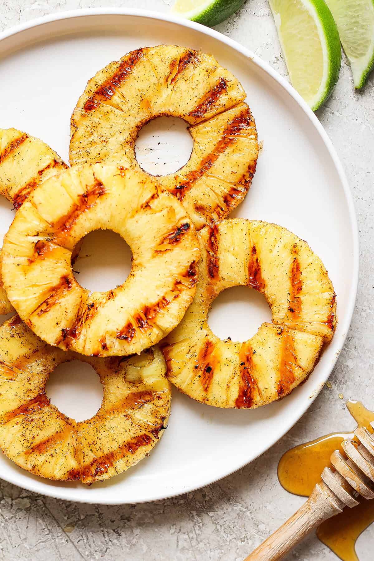 Pineapple rings with char marks after being grilled, on a plate.