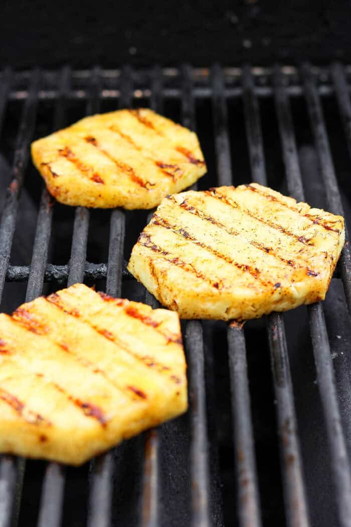 Slices of pineapple cool on the grill.