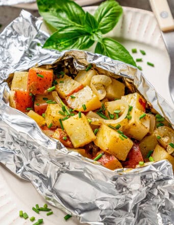 an opened foil packet of grilled potatoes