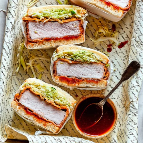 a tray of sliced pork katsu sandwiches with a bowl of sauce