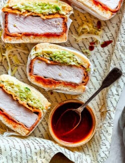 a tray of sliced pork katsu sandwiches with a bowl of sauce