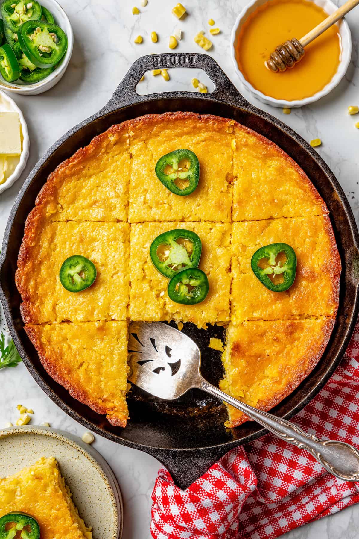 overhead photo of Jiffy corn casserole in a cast iron pan, cut into pieces