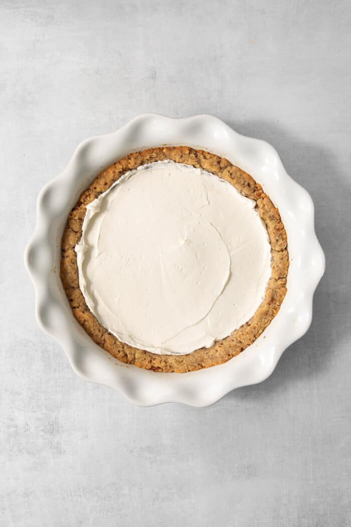 Spreading the cream cheese layer in the pie.