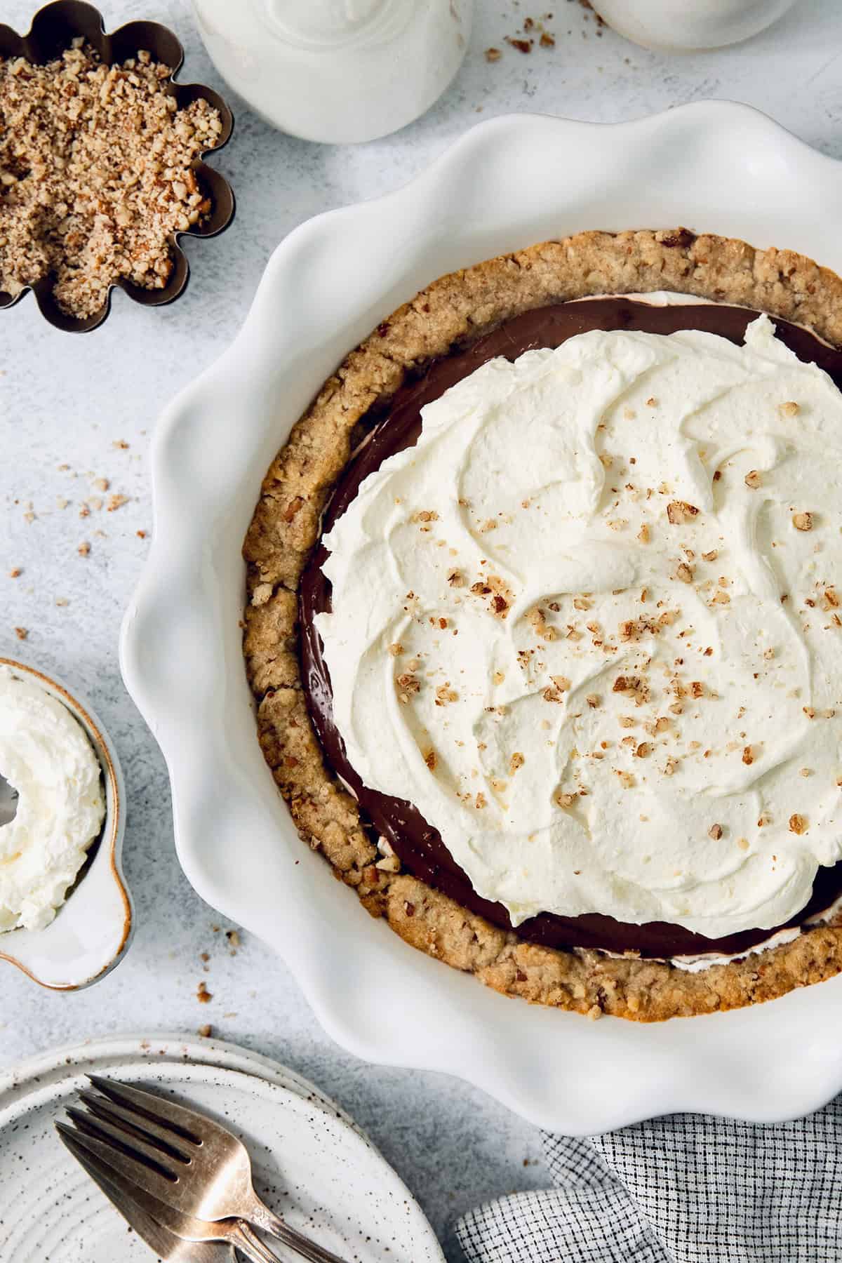 Angled photo of chocolate-cream cheese pie with fluffy whipped cream on top. 