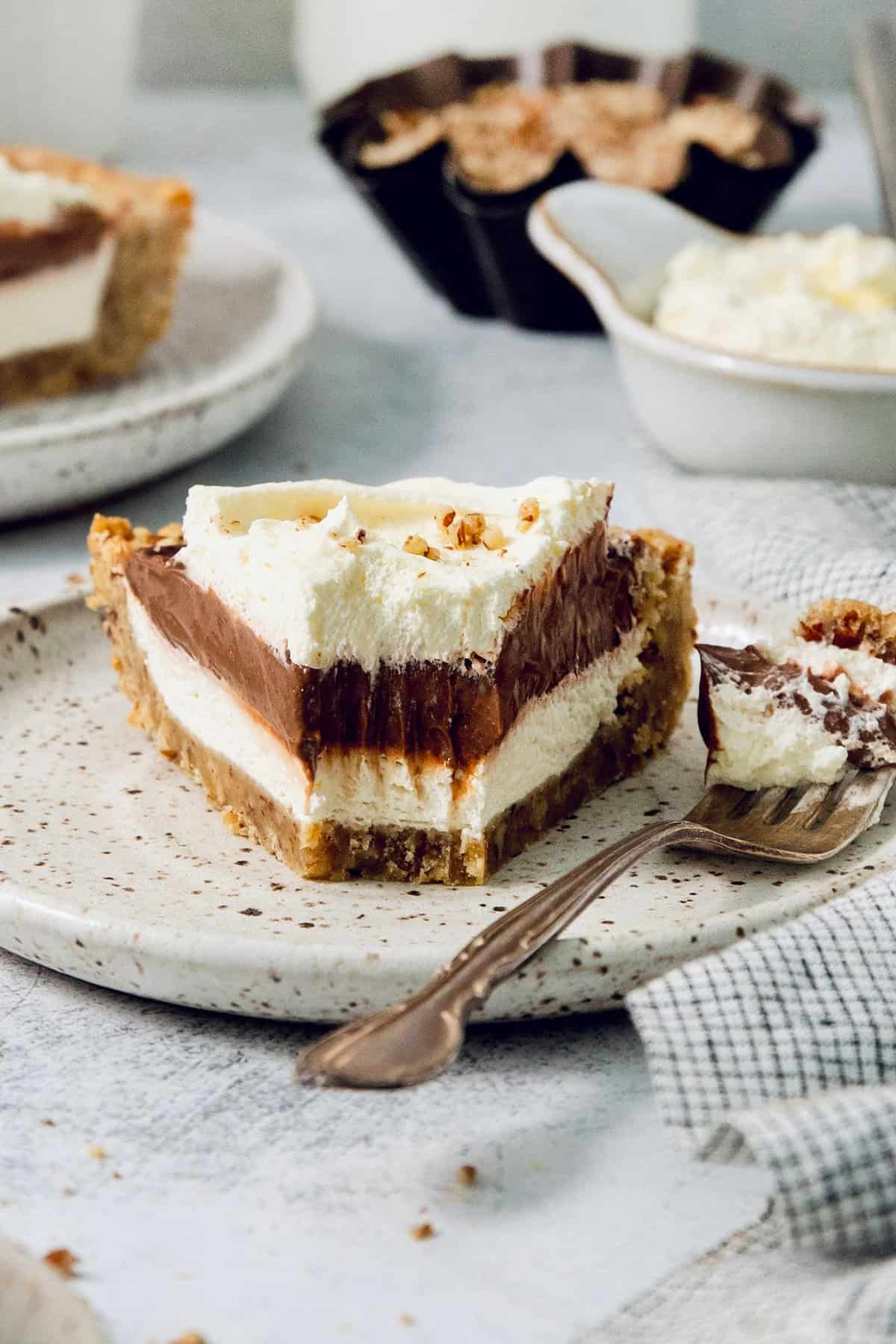 A slice of layered possum pie with whipped cream on top. 