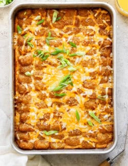 Baked tater tot casserole with melty cheese on top.