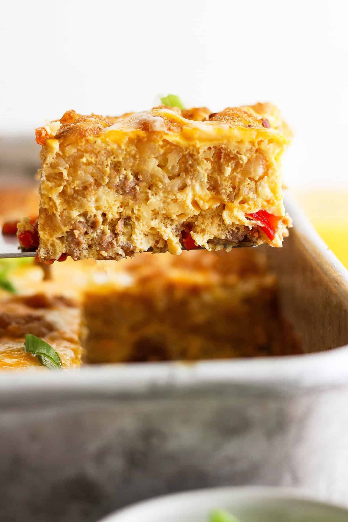 Close-up of a slice of tater tot casserole with eggs, sausage, and veggies. 