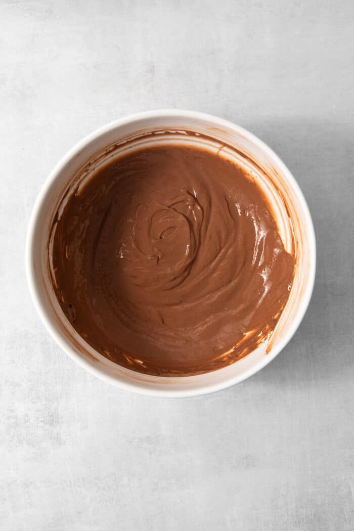 mixing the chocolate pudding layer, in a white mixing bowl