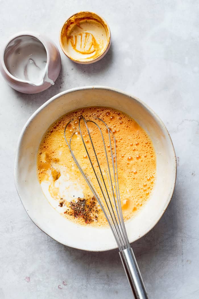 whisking egg mixture in a mixing bowl