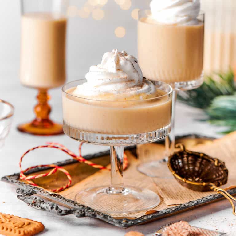 festive glasses of eggnog with twinkly lights in background