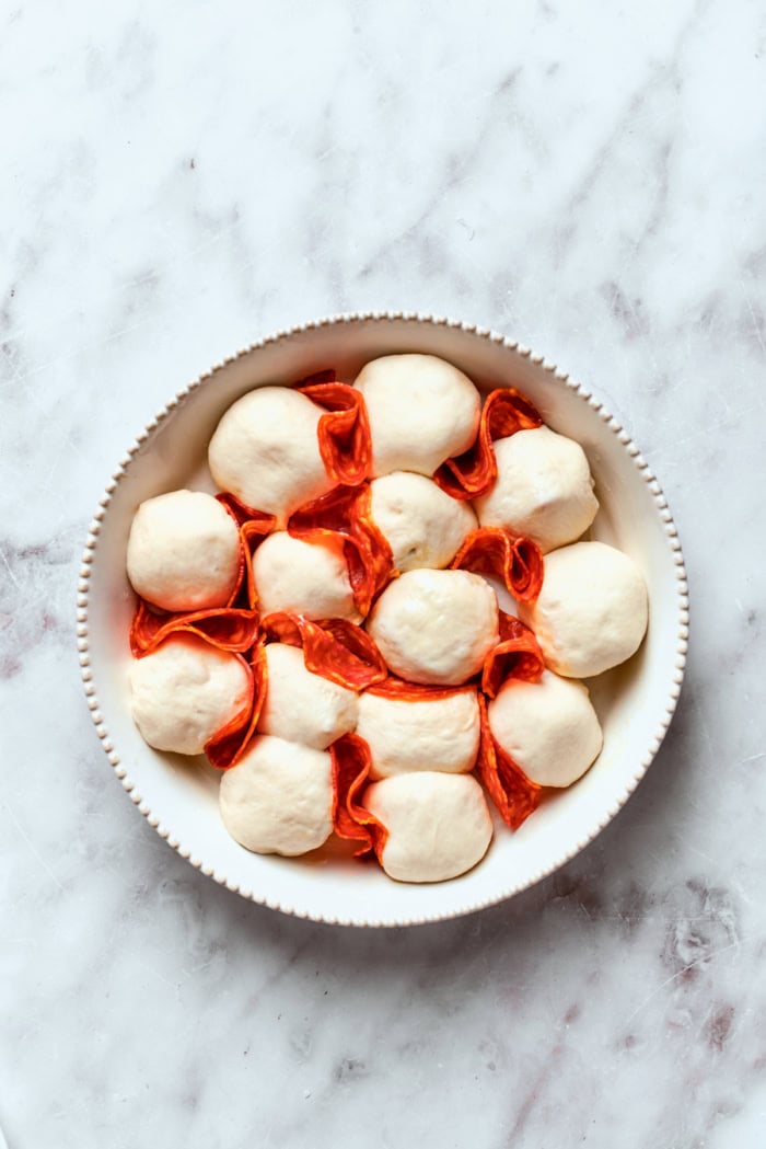 Pizza bites with chorizo tucked in between before baking