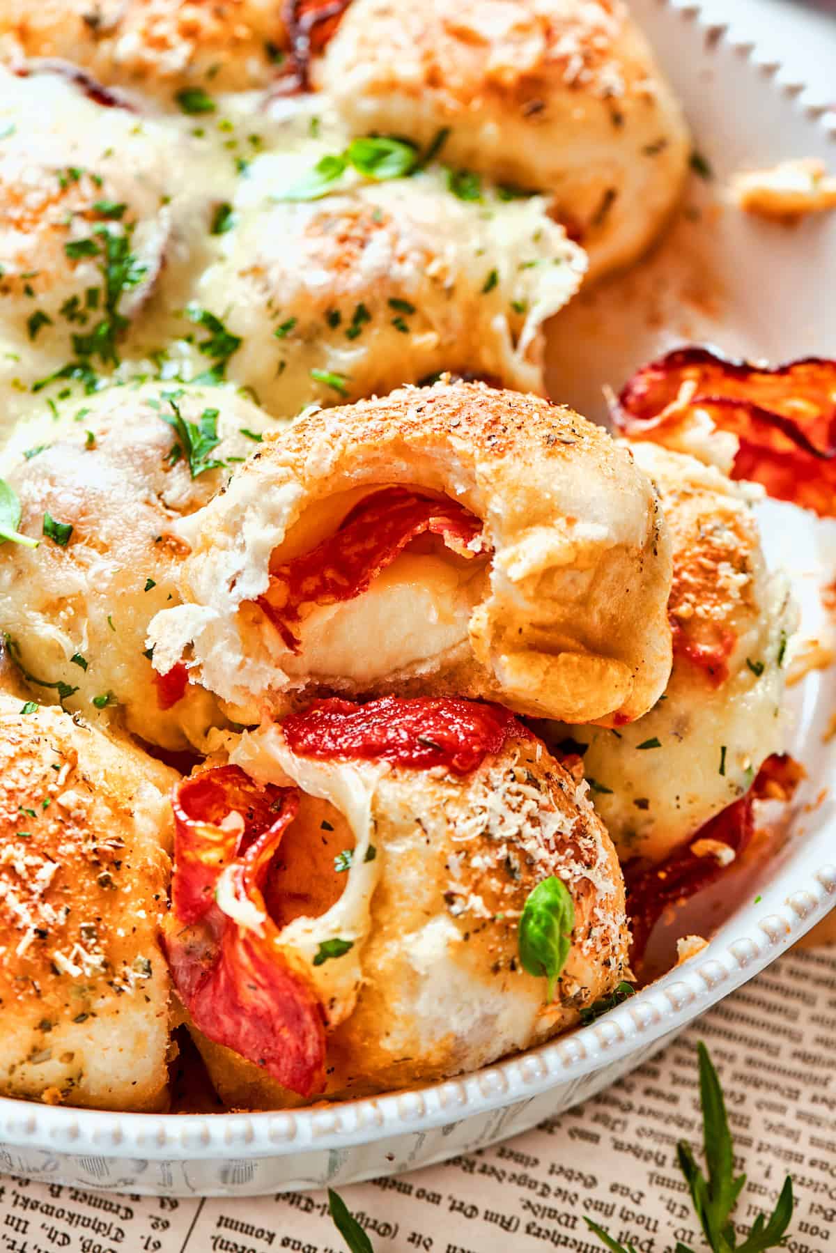 Pizza bites in dish, with bitten piece on top to show interior