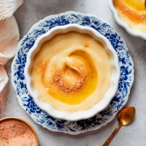 Norwegian rommegrot in a white bowl, with cinnamon-sugar and melted butter