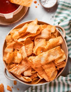 a bowl of homemade wonton chips with dipping sauce