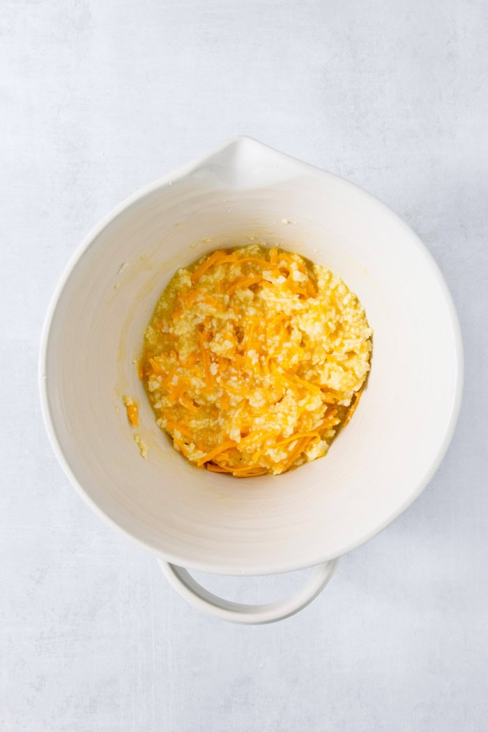 Cheese added to bowl for pandebono