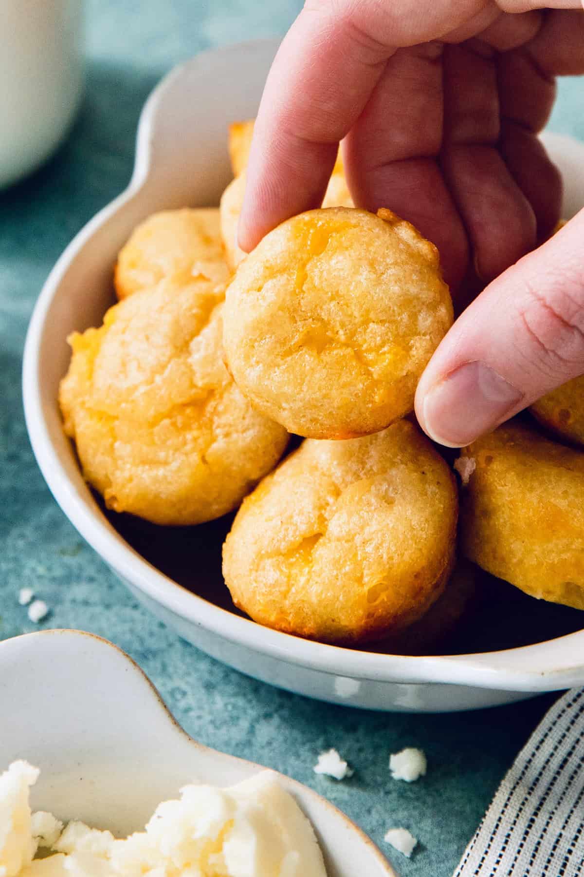 Handing picking up pandebono from bowl