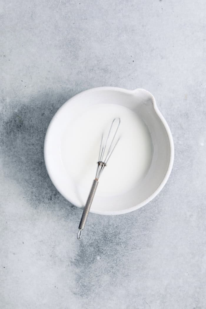 Cornstarch slurry in bowl with whisk