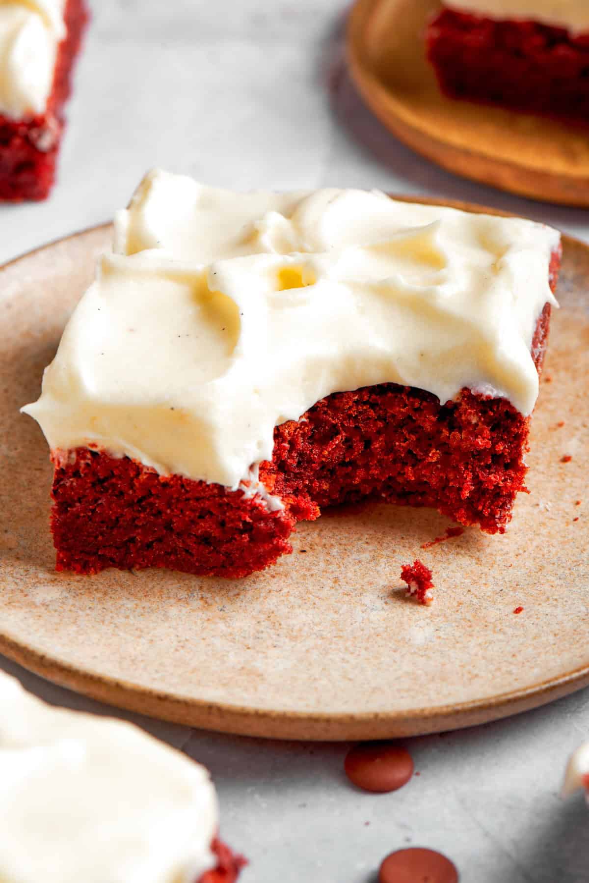 a red velvet brownie with cream cheese frosting, with a bite taken out of it
