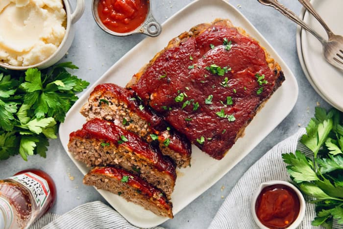 Overhead view of air fryer meatloaf on platter with three slices cut