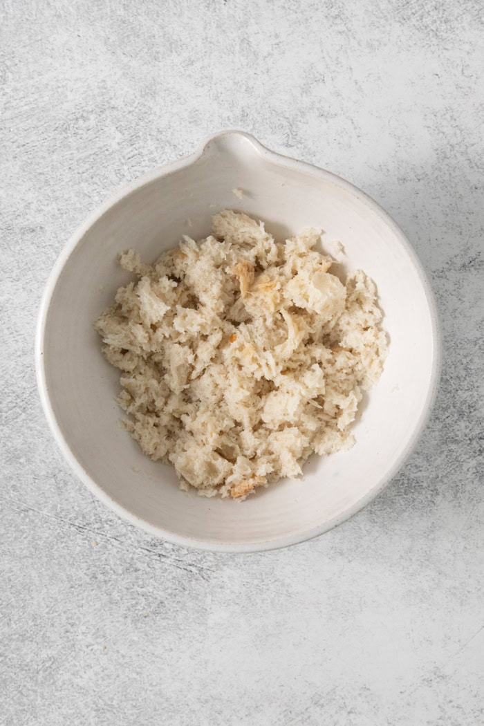 Overhead view of bread soaked in milk in bowl