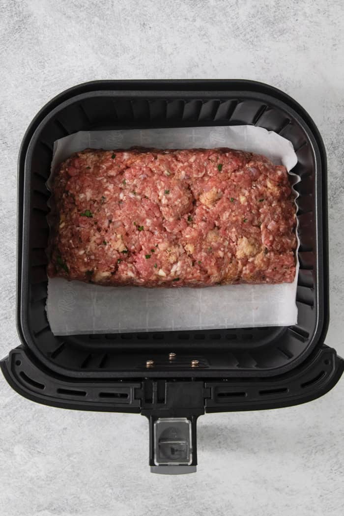 Overhead view of raw meatloaf in air fryer
