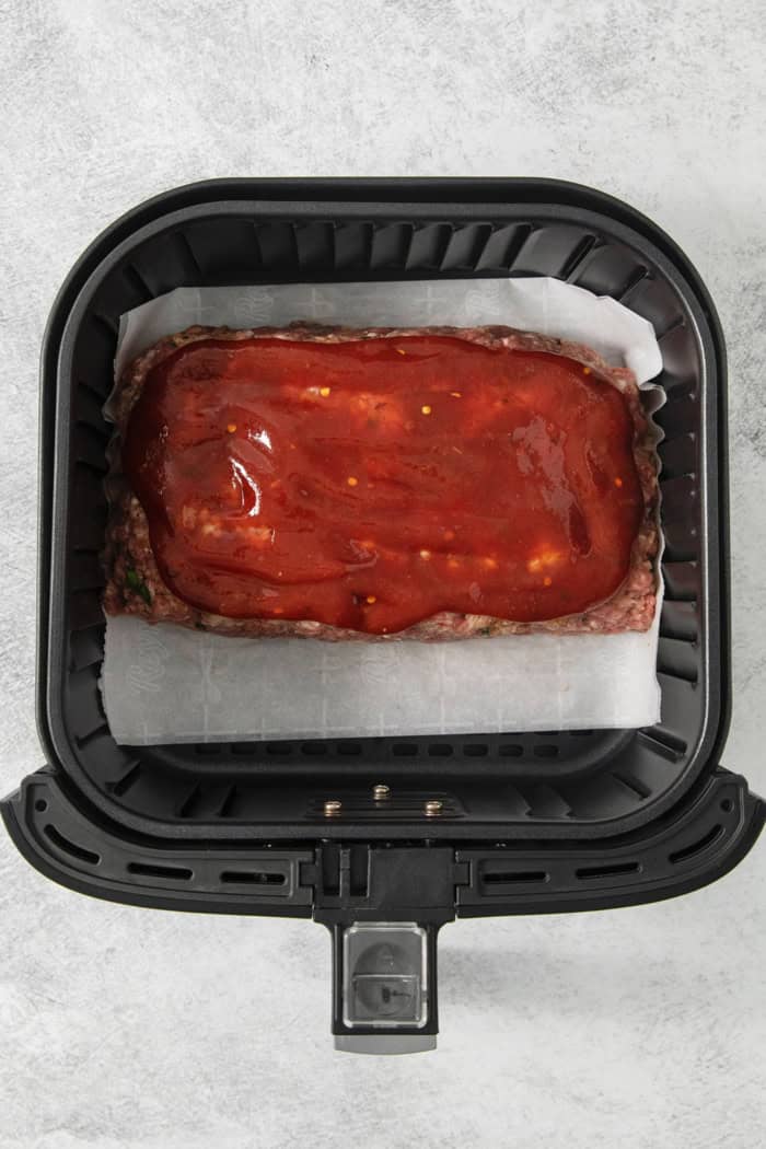 Overhead view of air fryer meatloaf in air fryer before cooking