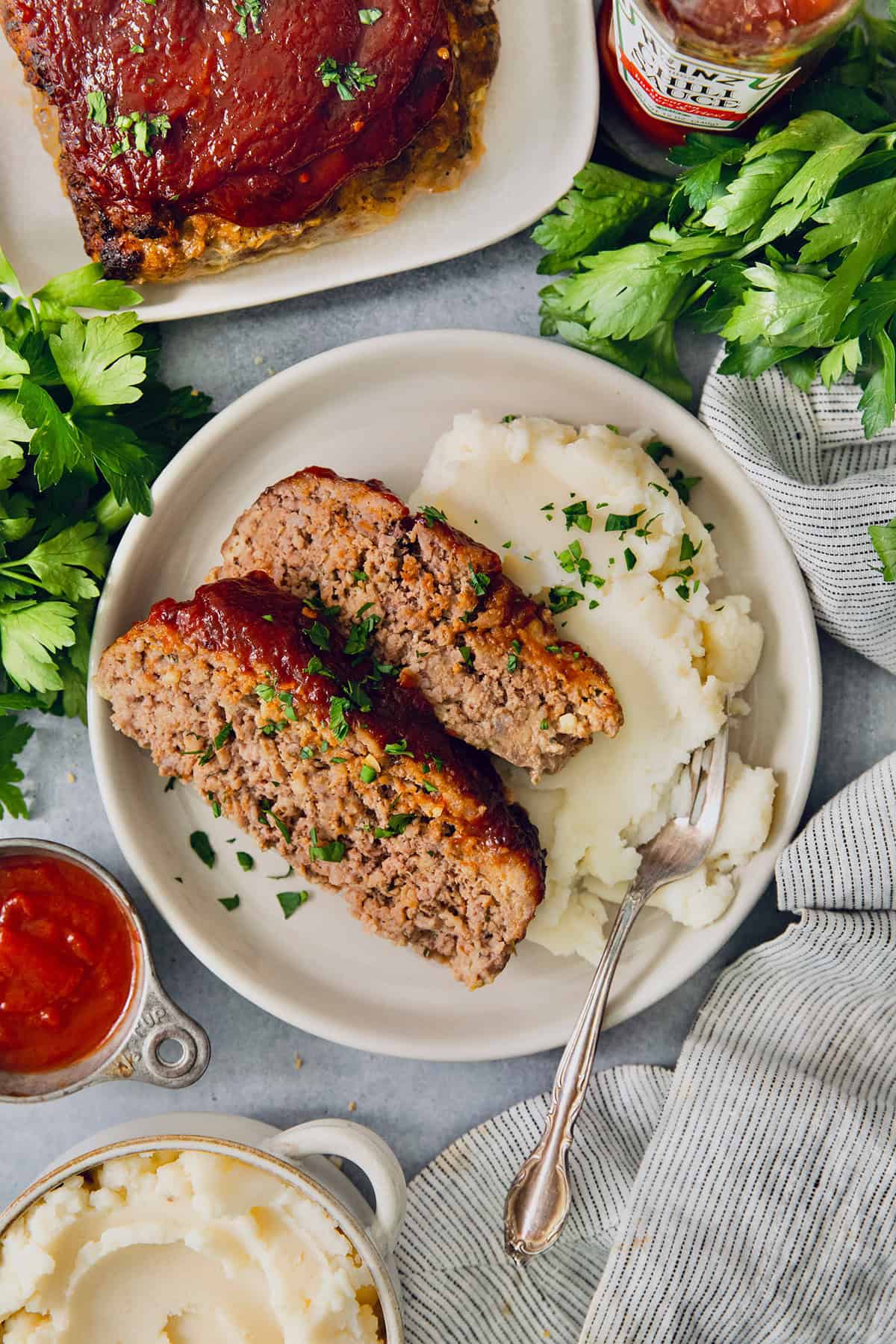 Overhead view of air fryer meatloaf on plate with mashed potatoes