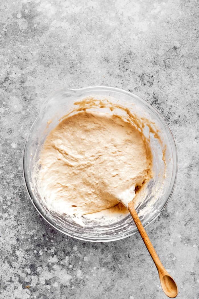 Overhead view of dough for English muffin bread being stirred in bowl