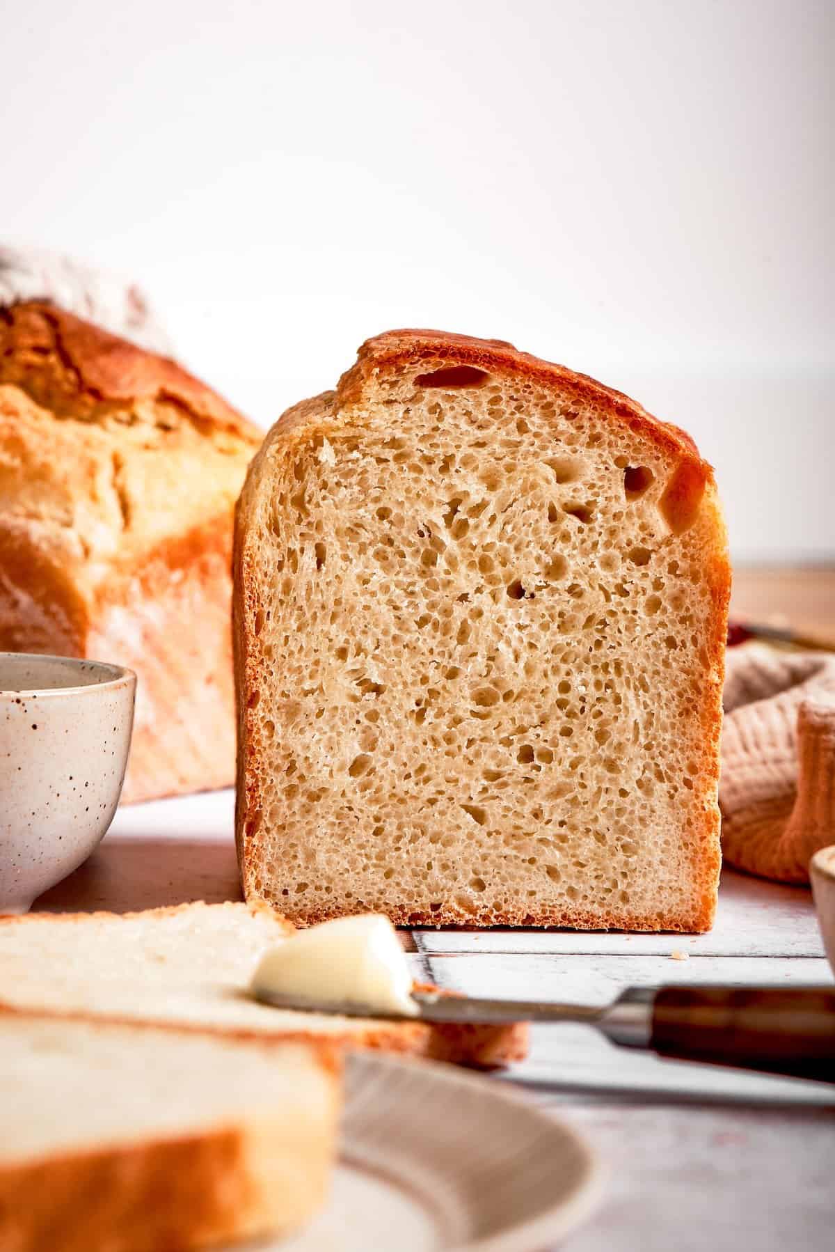 Side view of sliced English muffin bread, showing lofty height and crumb texture