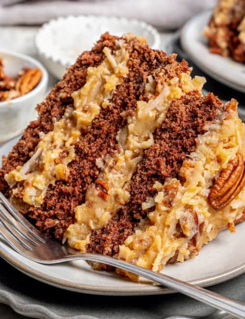 a piece of layered German chocolate cake on a plate