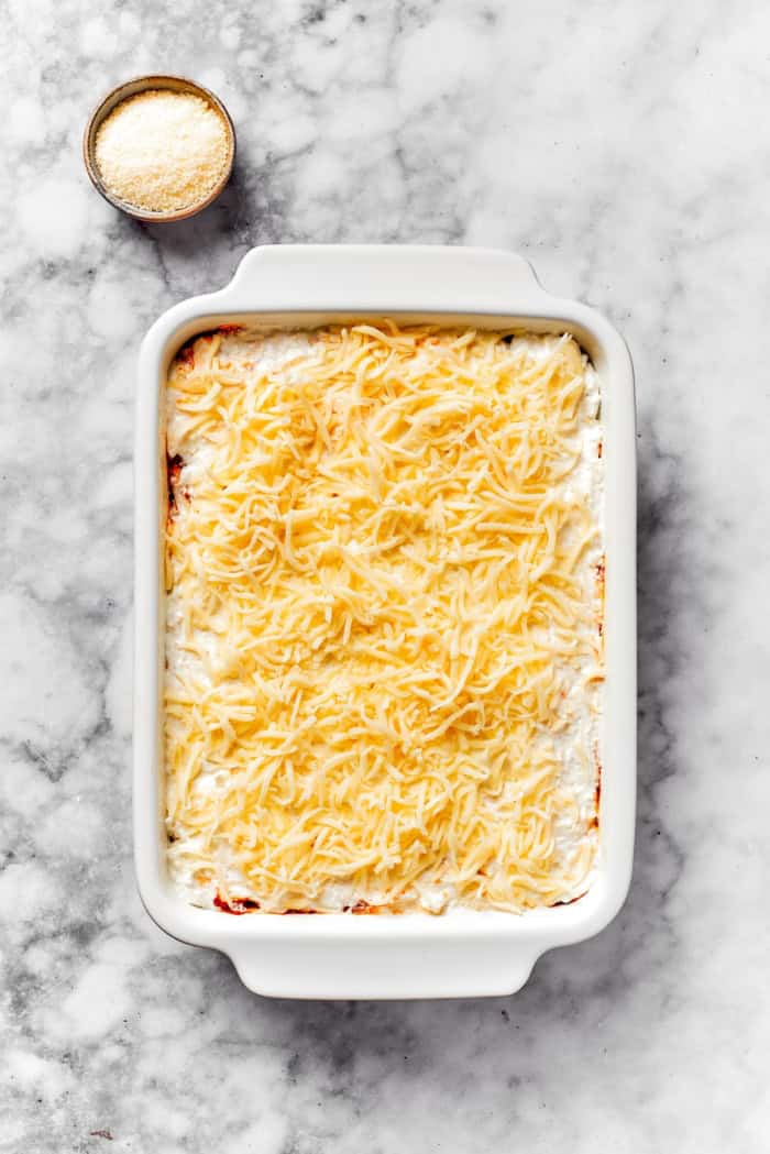 Mozzarella added to dish of lasagna beans