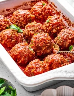 a white baking dish of porcupine meatballs in red sauce