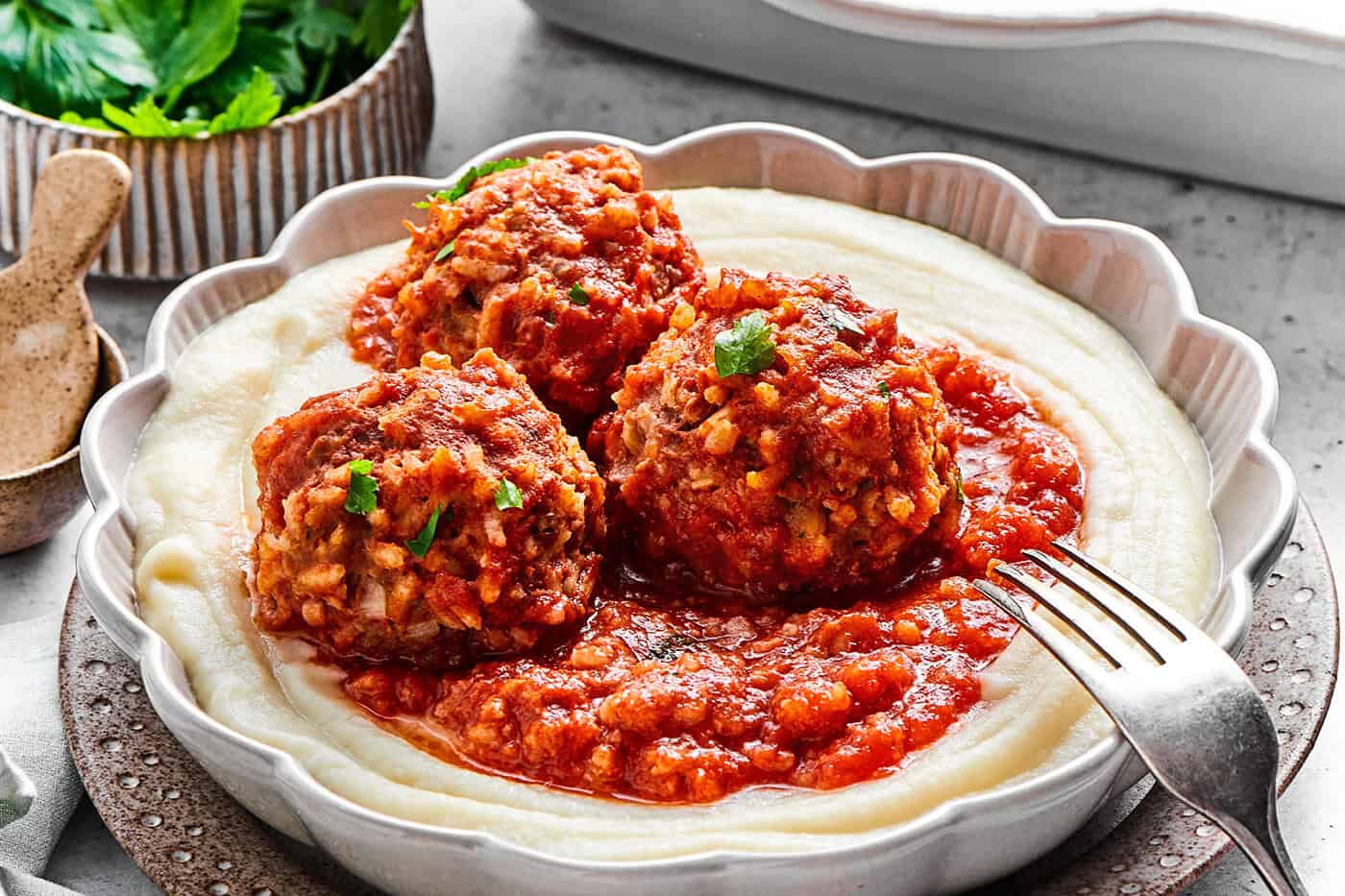 3 porcupine meatballs with red sauce, over creamy mashed potatoes