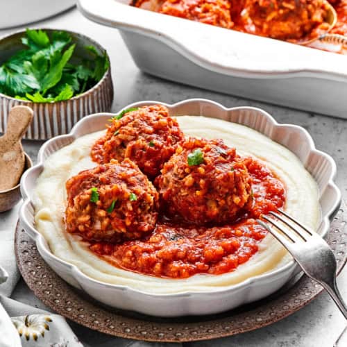 3 porcupine meatballs with red sauce, over creamy mashed potatoes