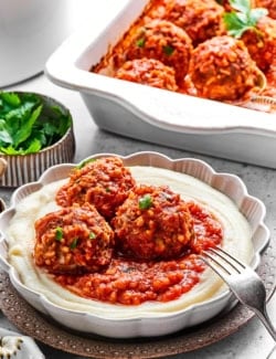 3 porcupine meatballs with red sauce, over creamy mashed potatoes