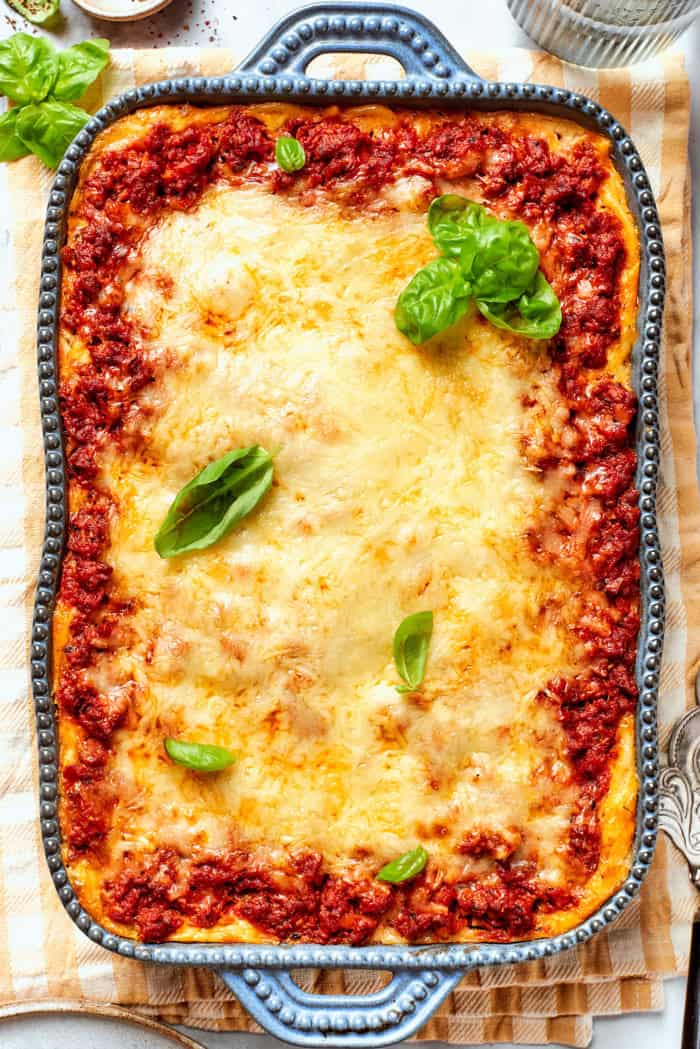 overhead photo of baked spaghetti casserole in a rectangular blue baking dish