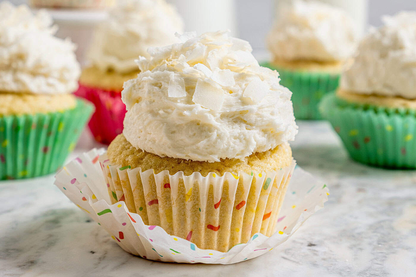 coconut cupcakes with coconut frosting, in pastel cupcake liners