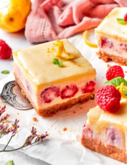 a serving spatula holding a lemon raspberry cheesecake bar