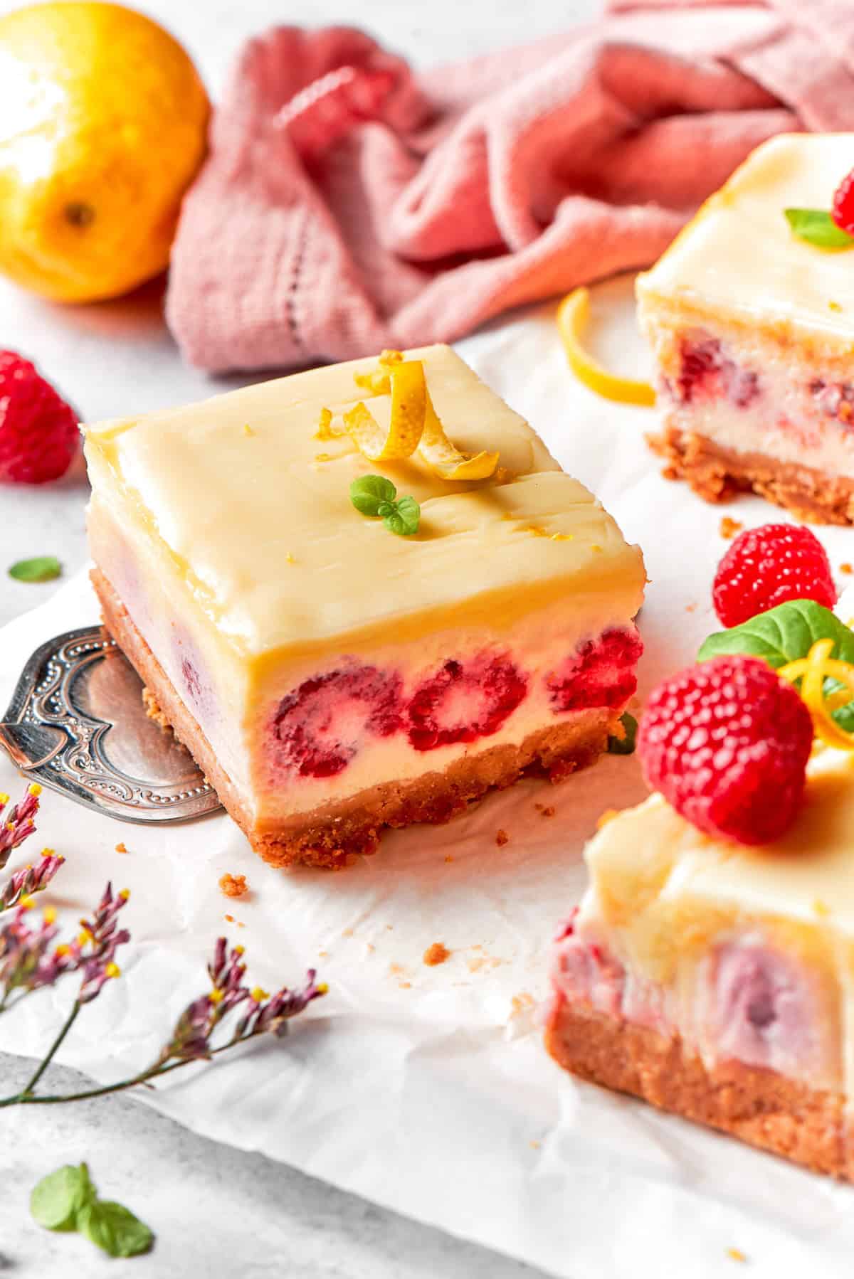 a serving spatula holding a lemon raspberry cheesecake bar